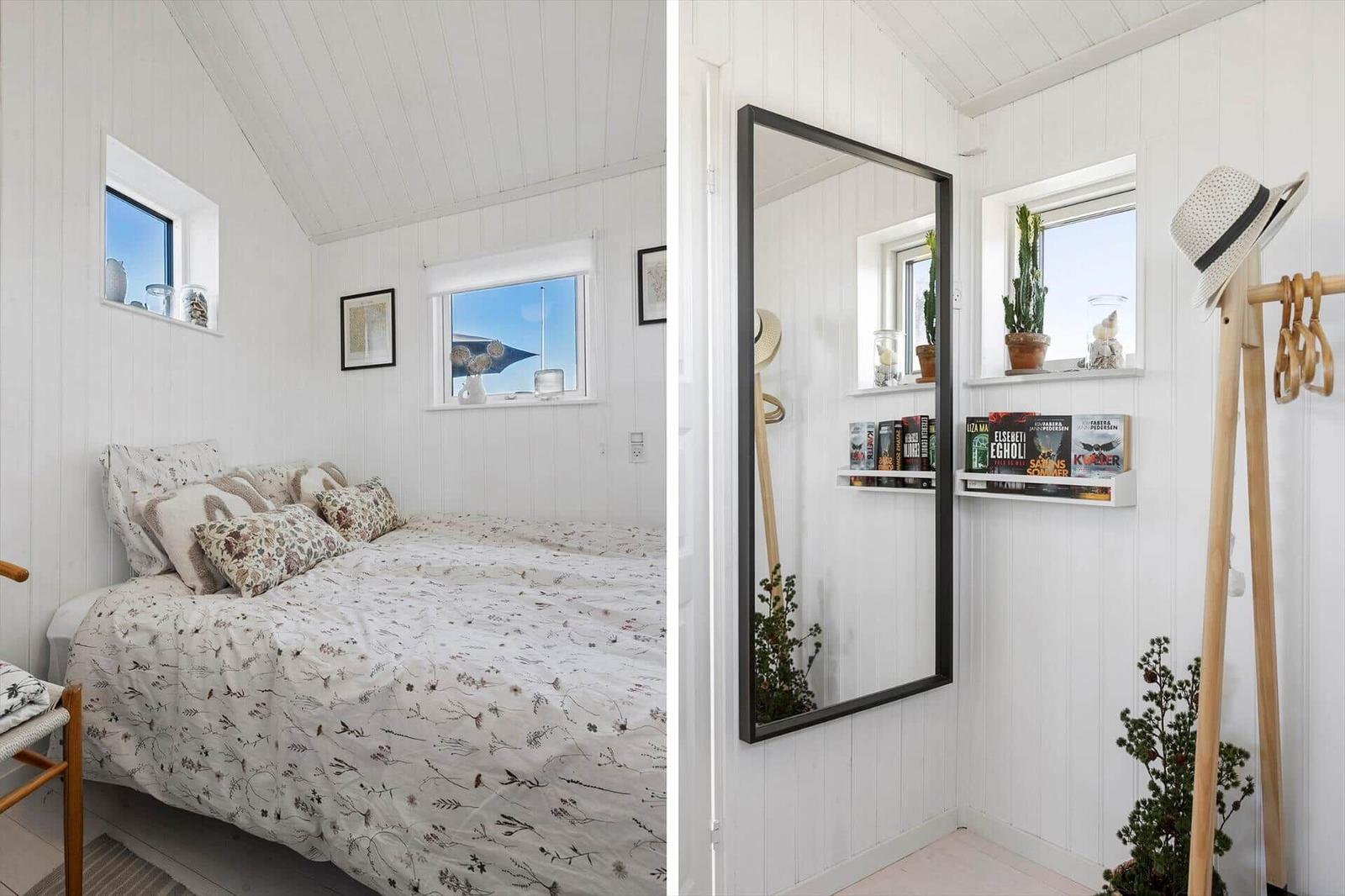 Schlafzimmer mit Bett, Fenstern und Spiegelwand. Hölzerne Stühle und Pflanzen.