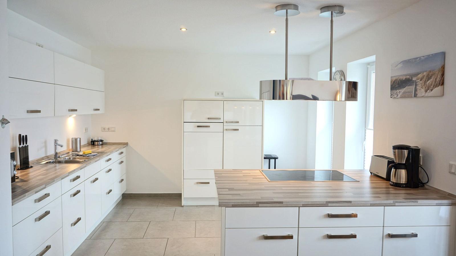Moderne Küche mit weißen Schränken und Holzoberflächen