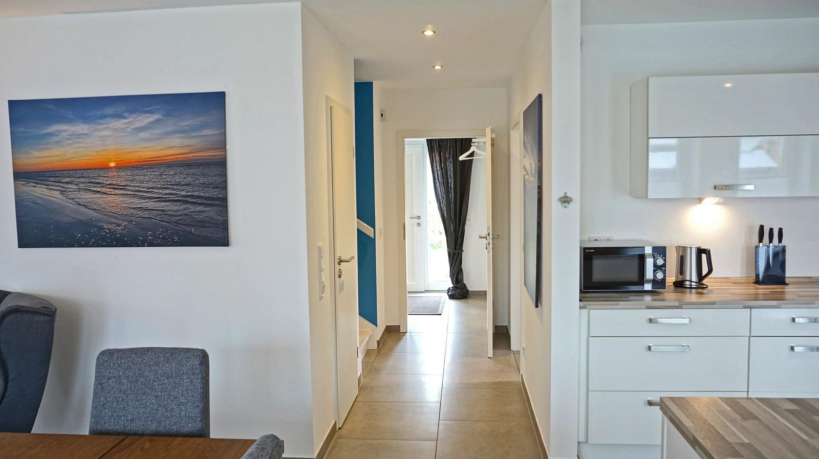 Wohnung mit Küche, Flur und Wandbild am Strand