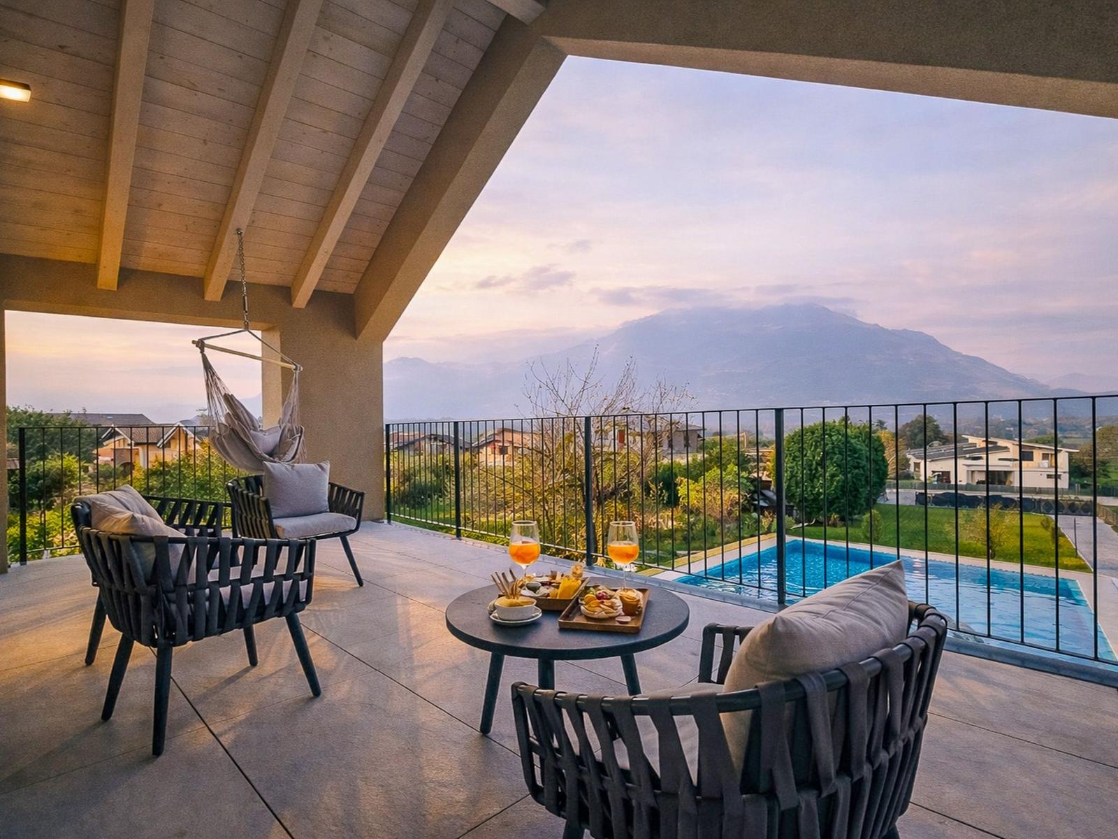 Terrasse mit Sitzgelegenheiten und Poolblick auf Berge