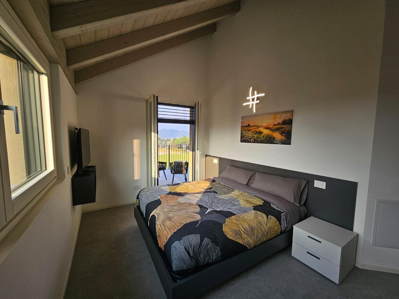 Schlafzimmer mit Bett, TV und Balkonansicht.