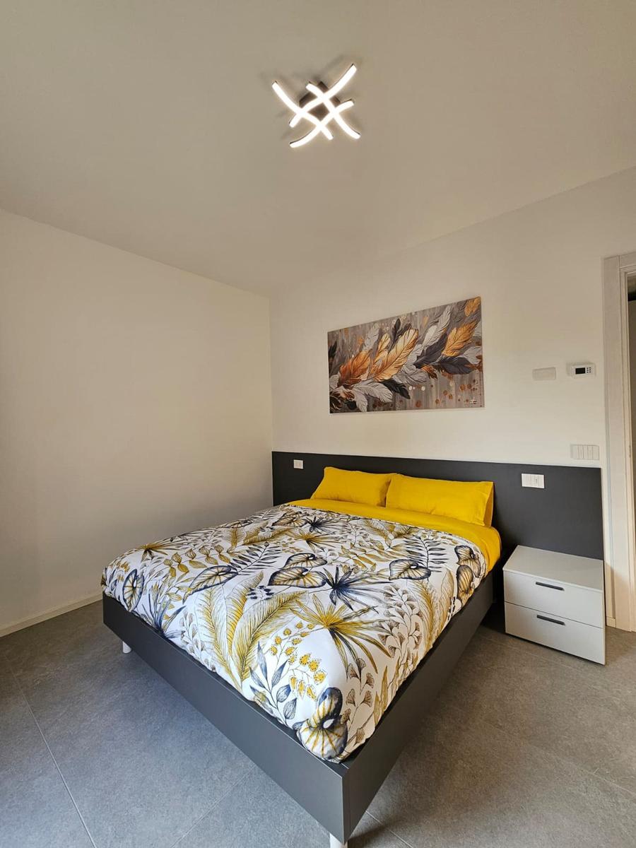 Schlafzimmer mit Bett, Nachttisch und Wandbild.
