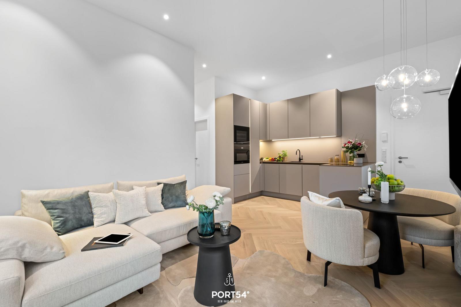 Wohnbereich mit Sofa, Esstisch und moderner Küche.