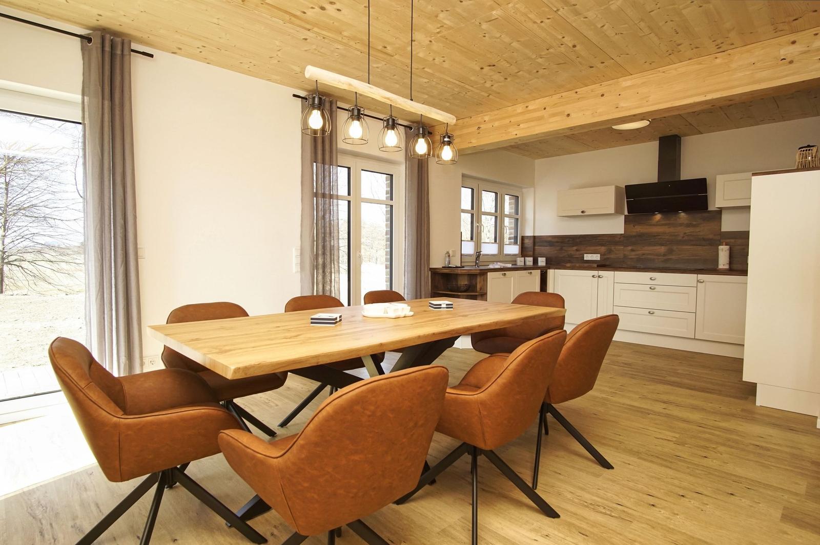 Essbereich mit Holztisch und braunen Stühlen unter Holzdecke