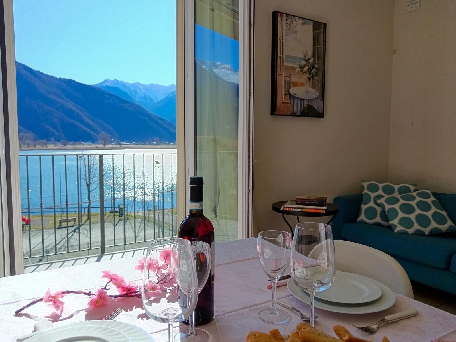 Tisch mit Wein und Blumen vor Balkon mit Bergblick