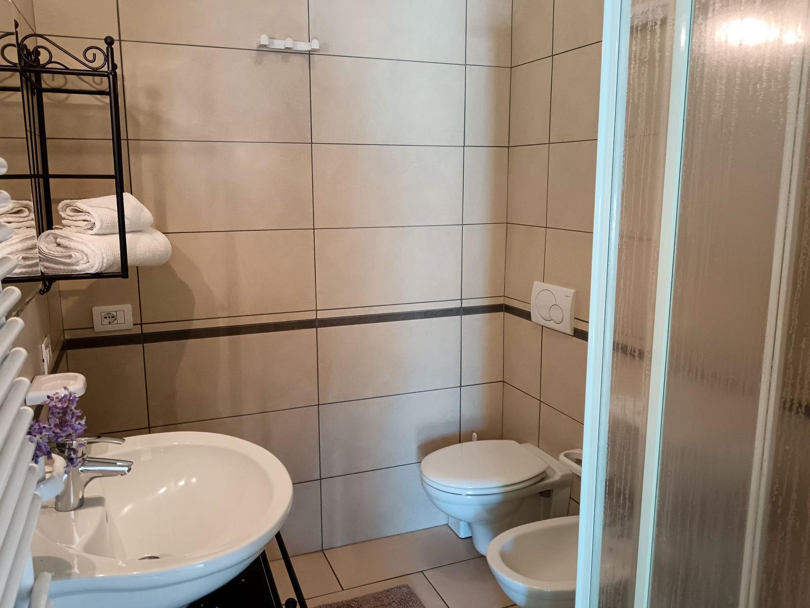 Badezimmer mit Toilette, Waschbecken und Dusche.