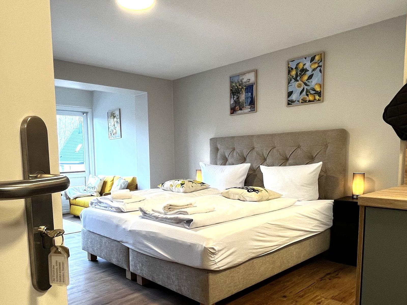Schlafzimmer mit Bett, Nachttisch und Wandbildern