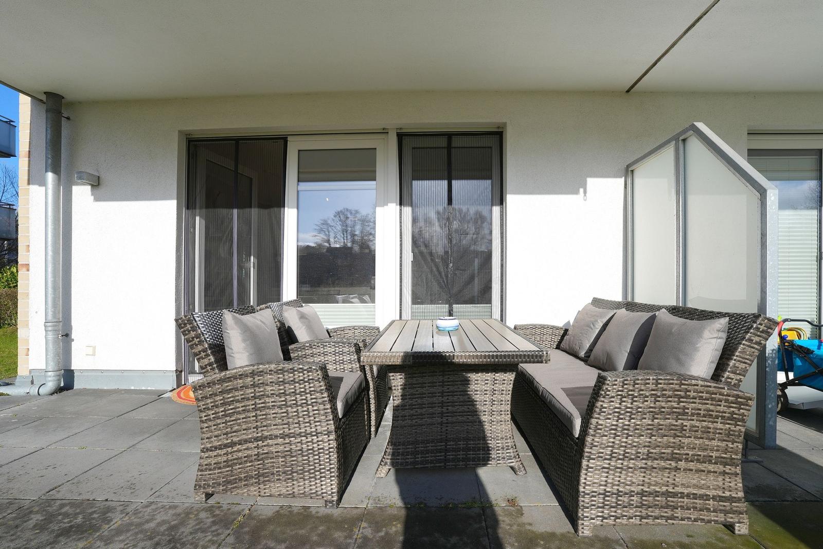 Terrasse mit Sitzgruppe und Tisch unter Dach