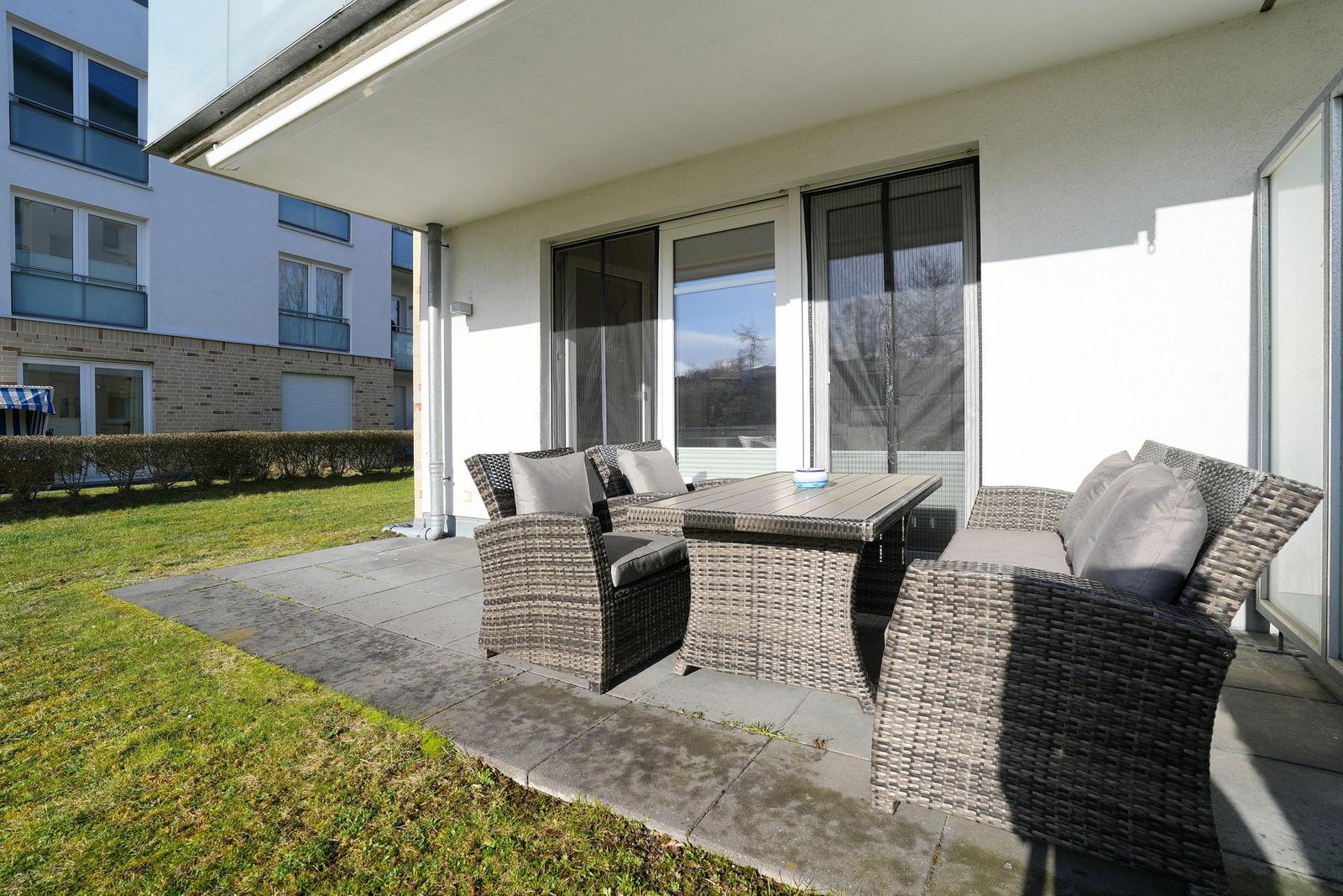 Terrasse mit Sitzgruppe und Tisch unter Dach