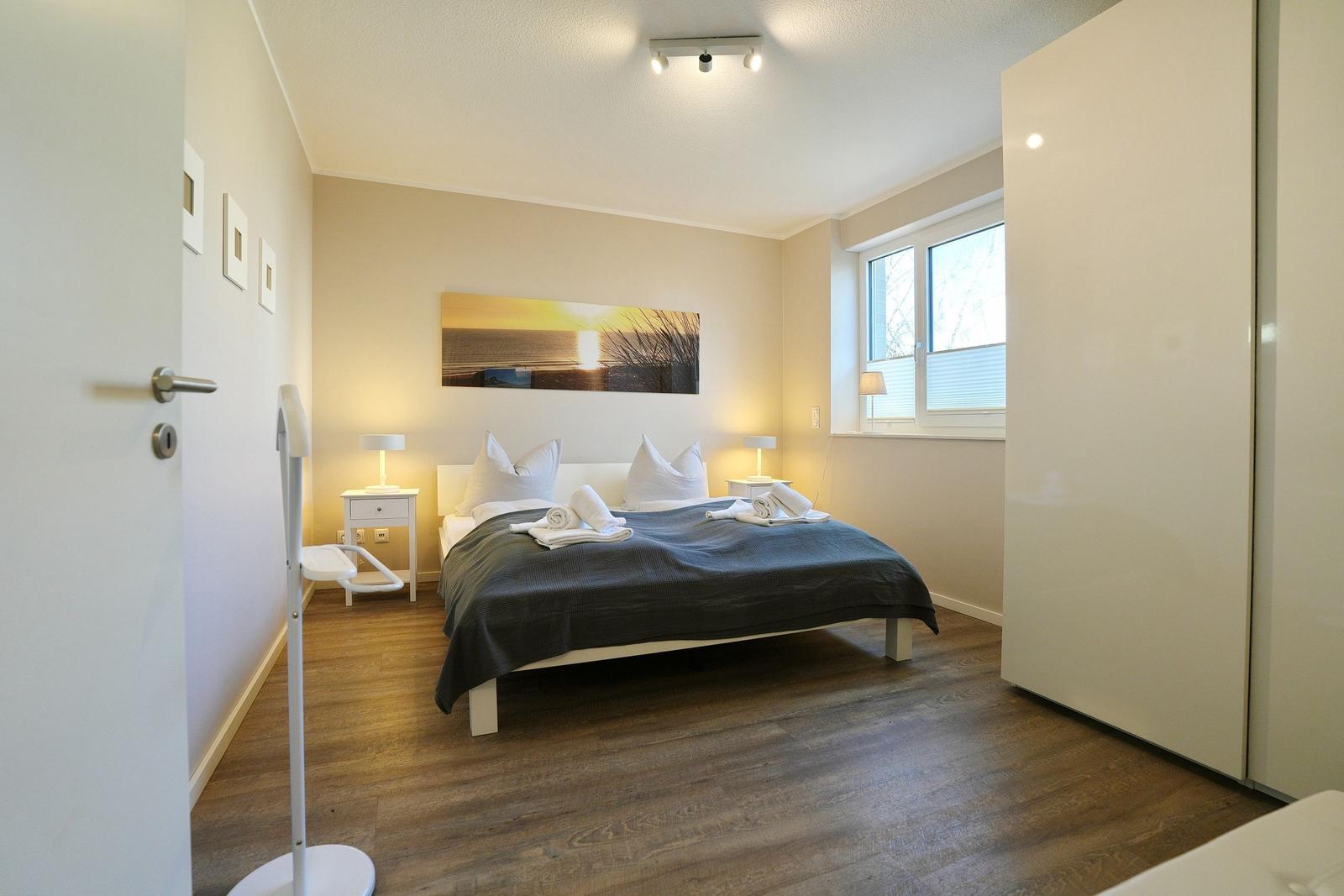 Schlafzimmer mit Bett, Nachttischen und Fenster