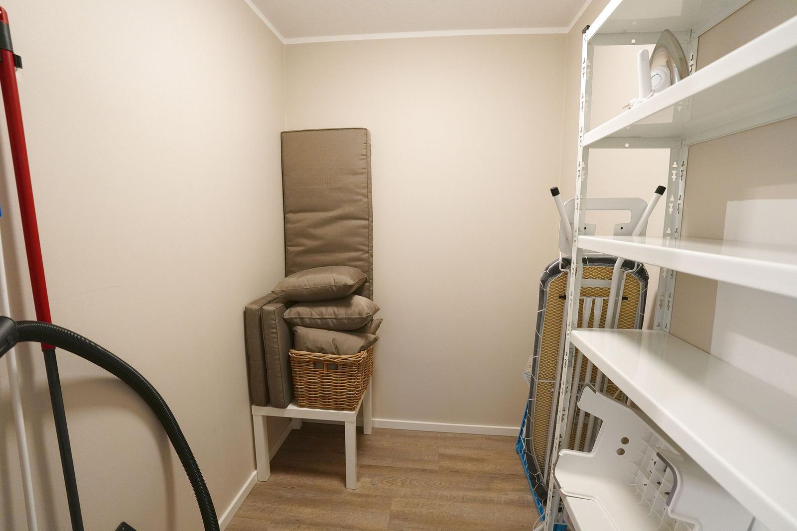 Wohnzimmer mit Stuhl, Kissen und Regal