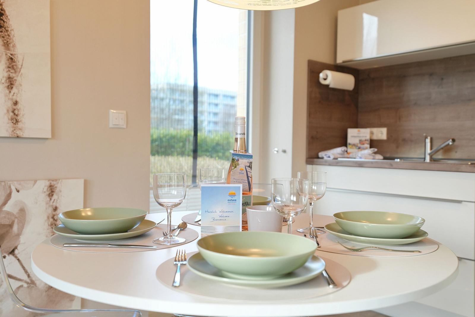 Rundtisch mit Geschirr und Flasche vor Fenster