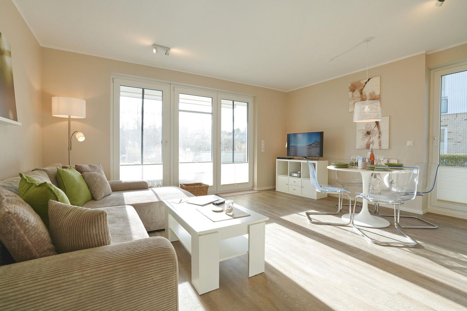 Wohn- und Essbereich mit Sofa, Esstisch und TV.