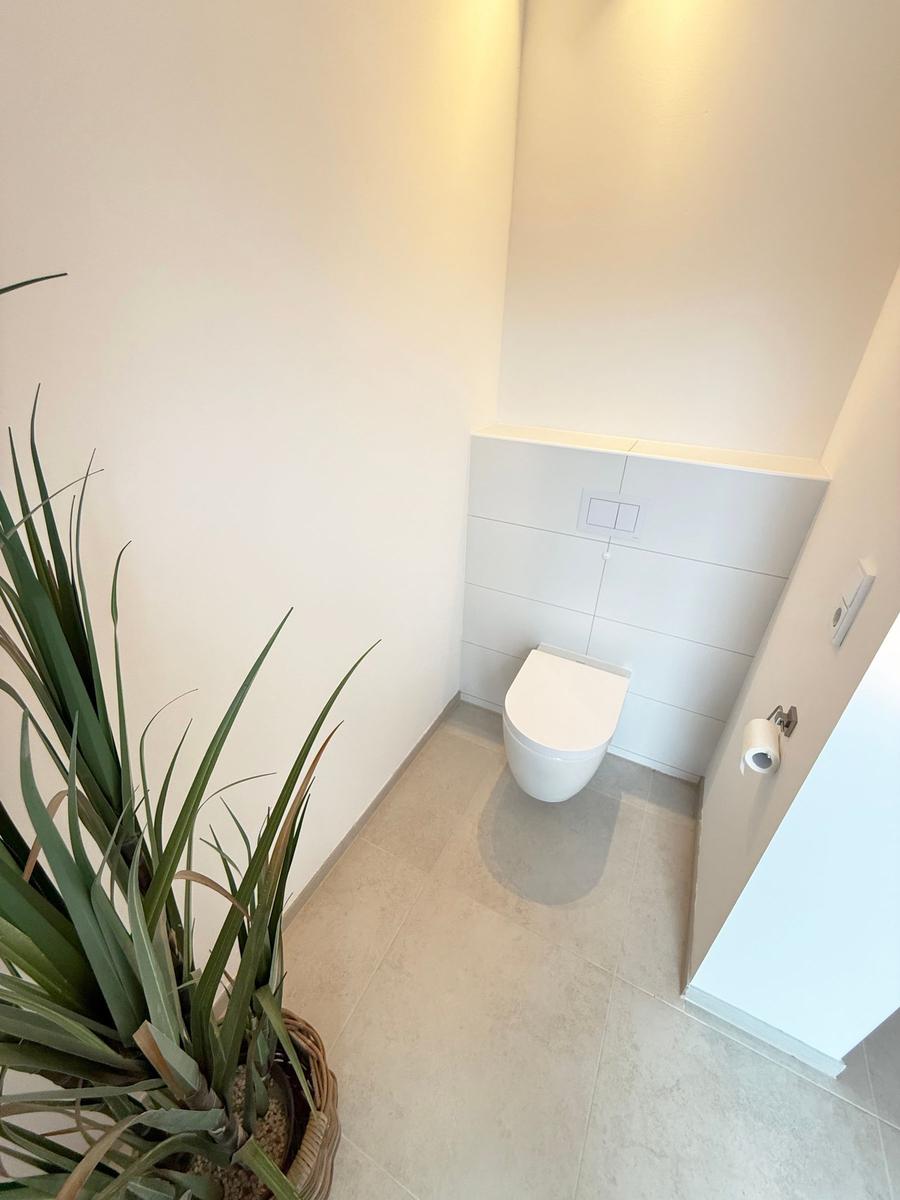 Bathroom with toilet and plant
