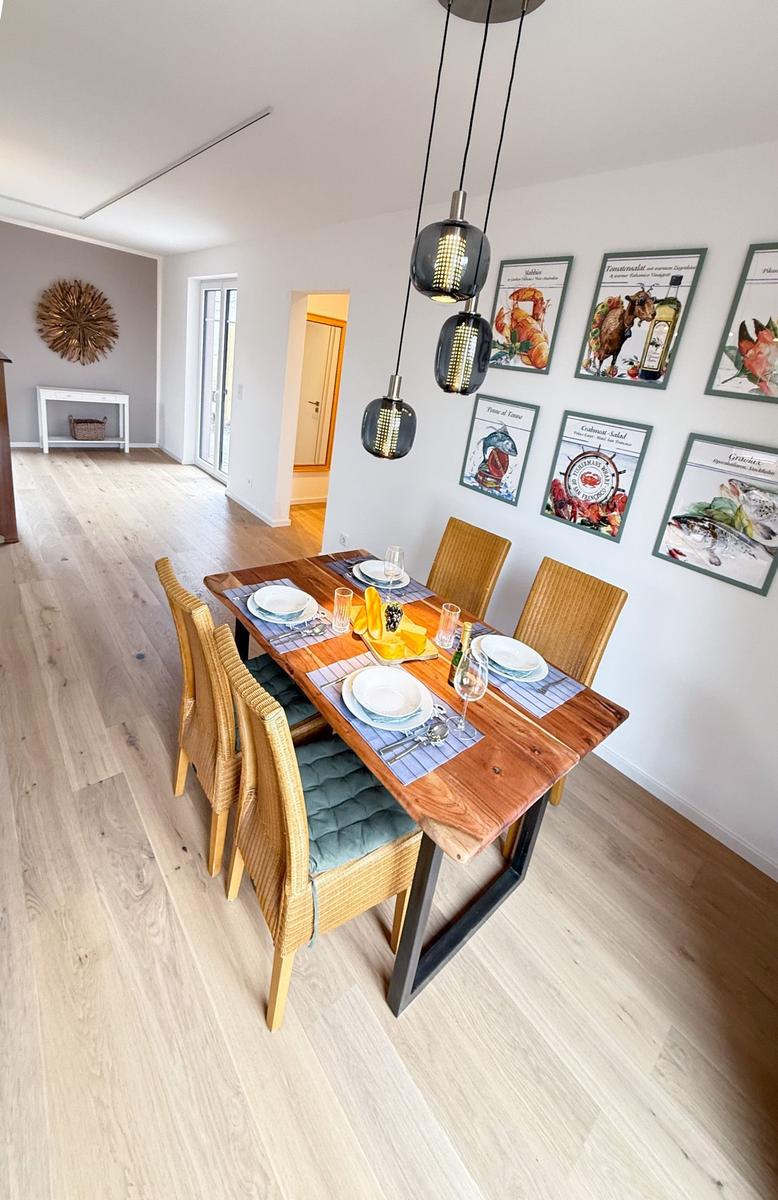 Dining room with wooden table, chairs, and wall pictures