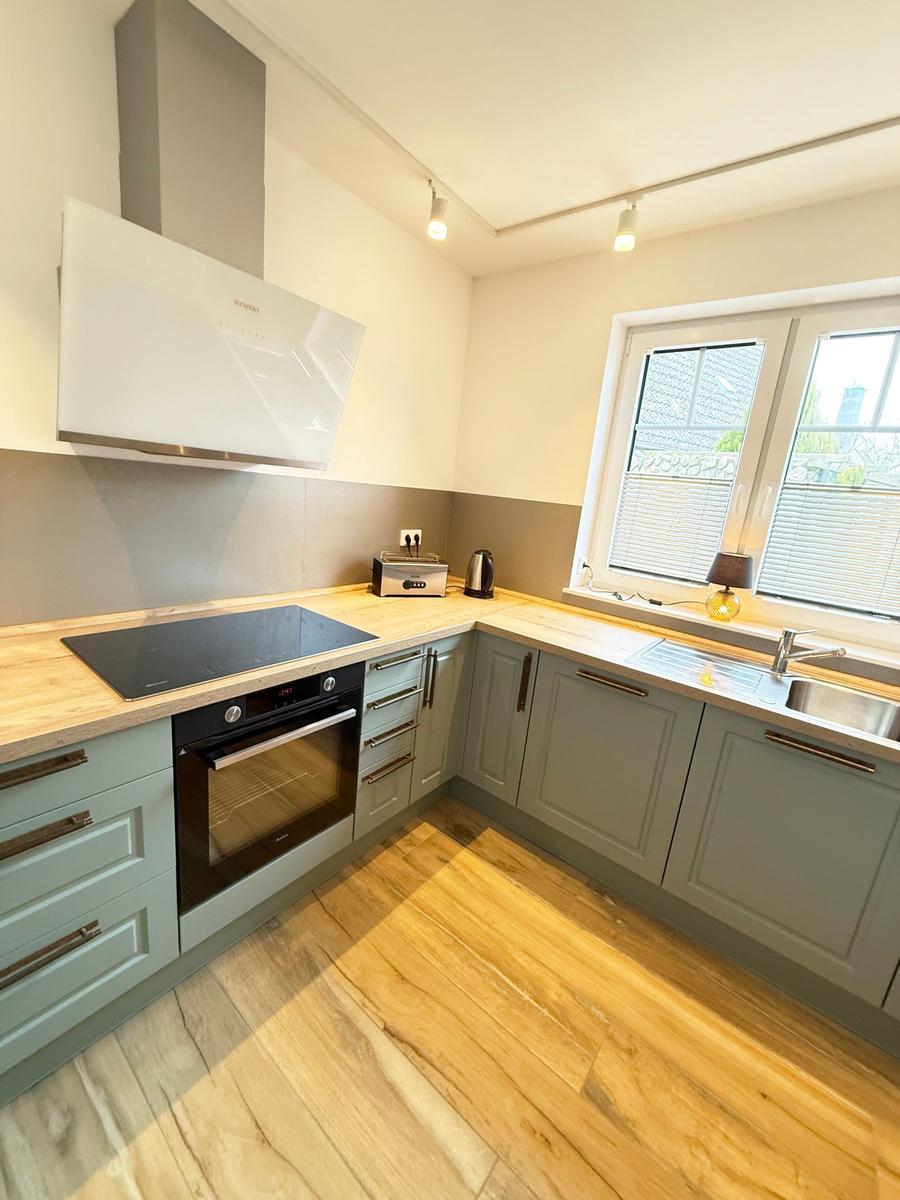 Kitchen with gray cabinets, wooden surfaces, and window view.