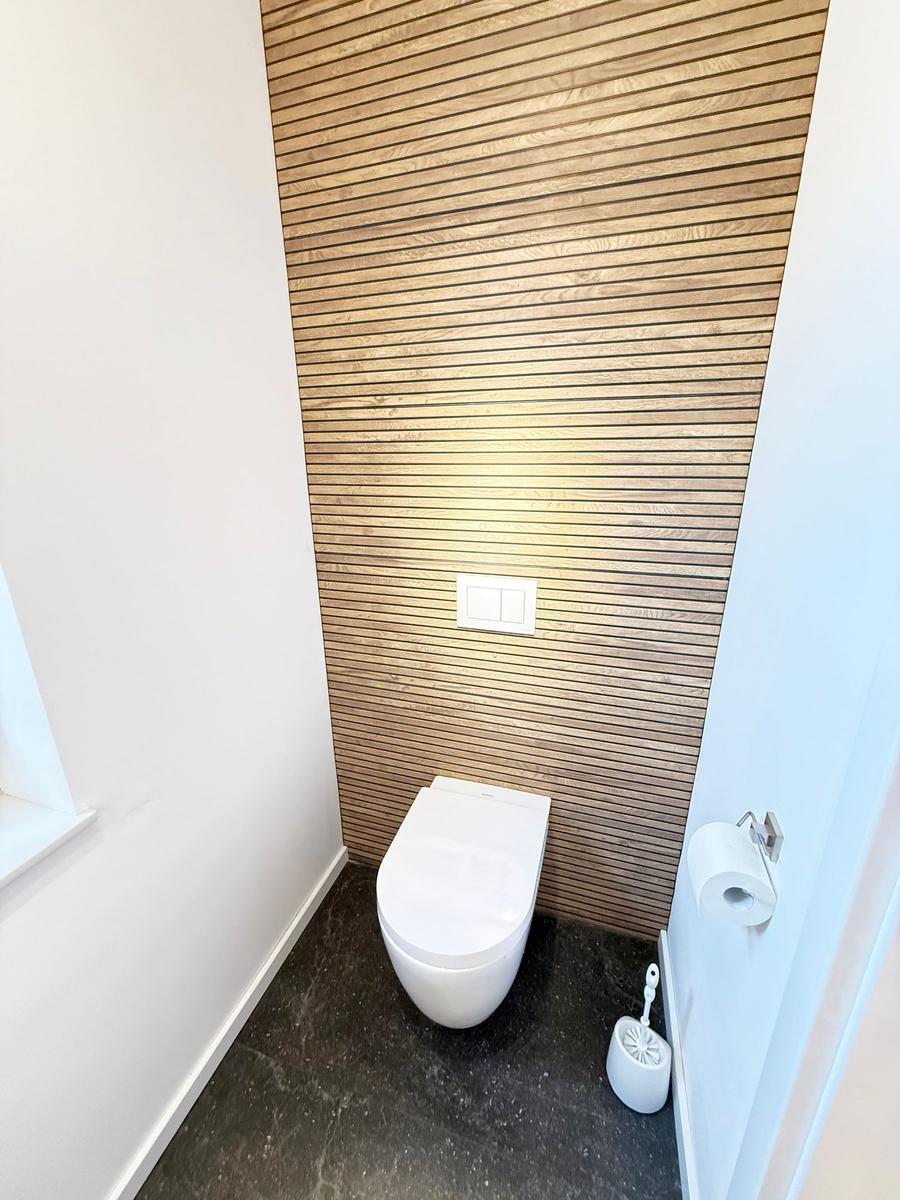 Toilet with wooden wall and toilet paper holder