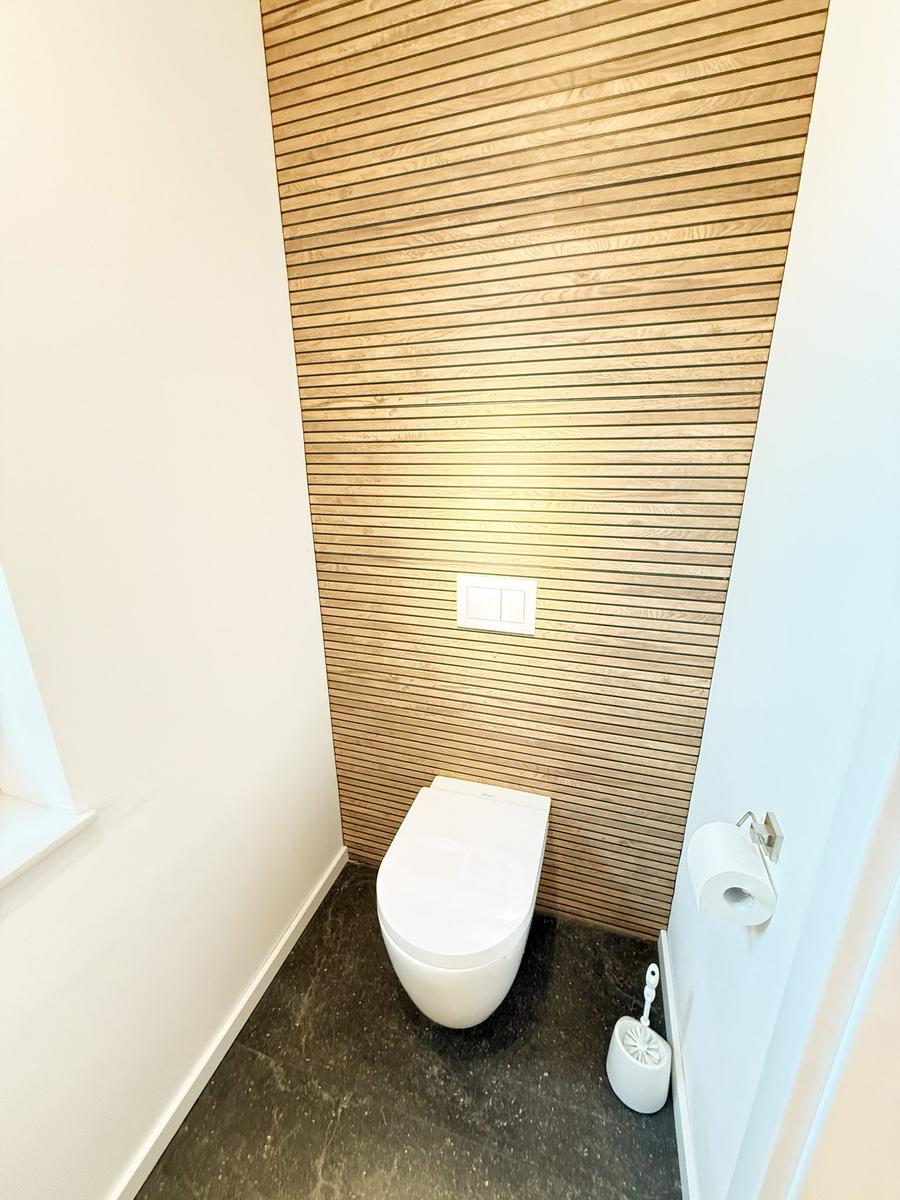 Toilet with wooden wall and toilet paper holder