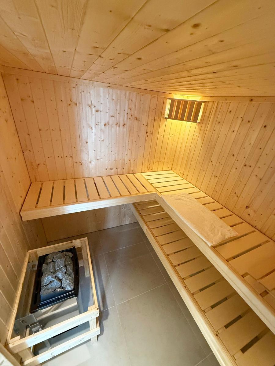 Wood sauna with benches and stone heater.