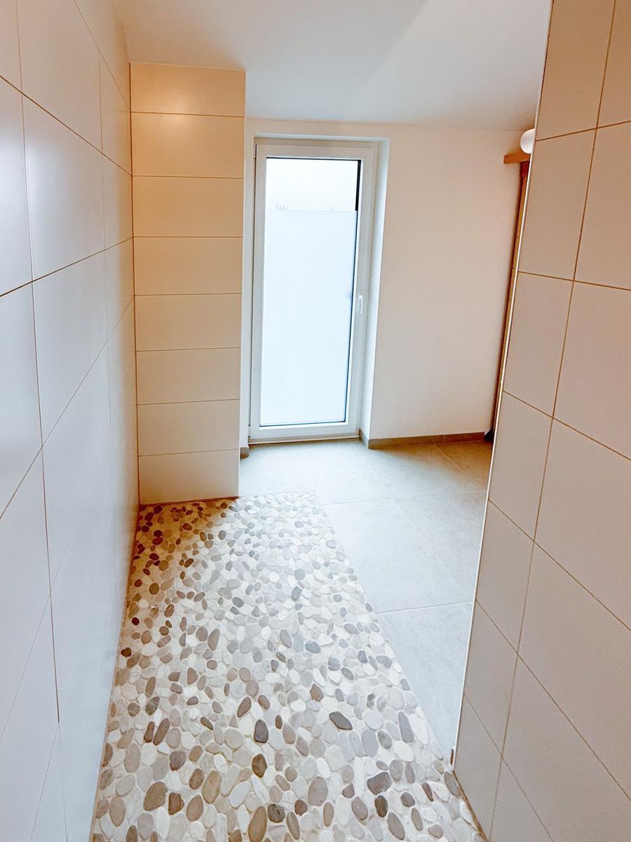 Hallway with pebble floor and window to outside door.