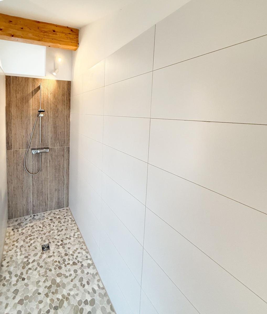 Shower area with wooden wall and stone floor