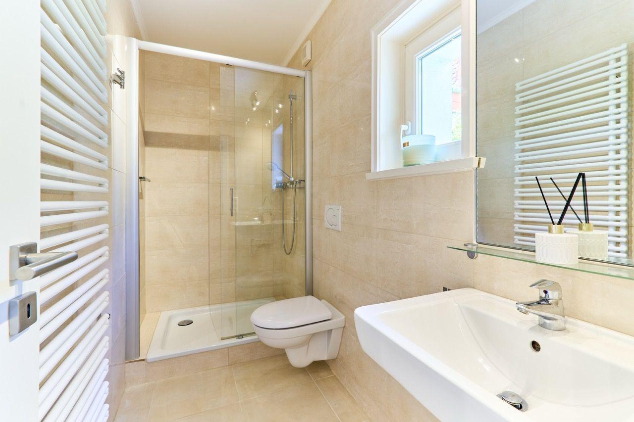 Badezimmer mit Dusche, Toilette und Waschbecken.