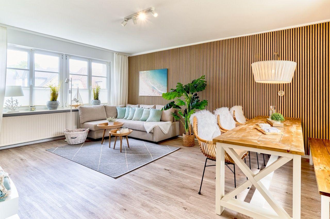Wohn- und Essbereich mit Holzwand, Sofa und Holztisch.