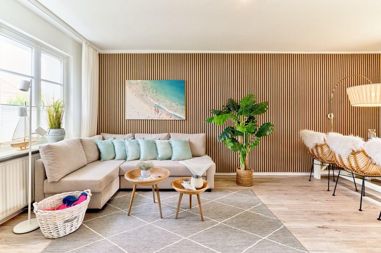 Wohnzimmer mit Sofa, Holzwand, Pflanze und Sitzgelegenheiten.