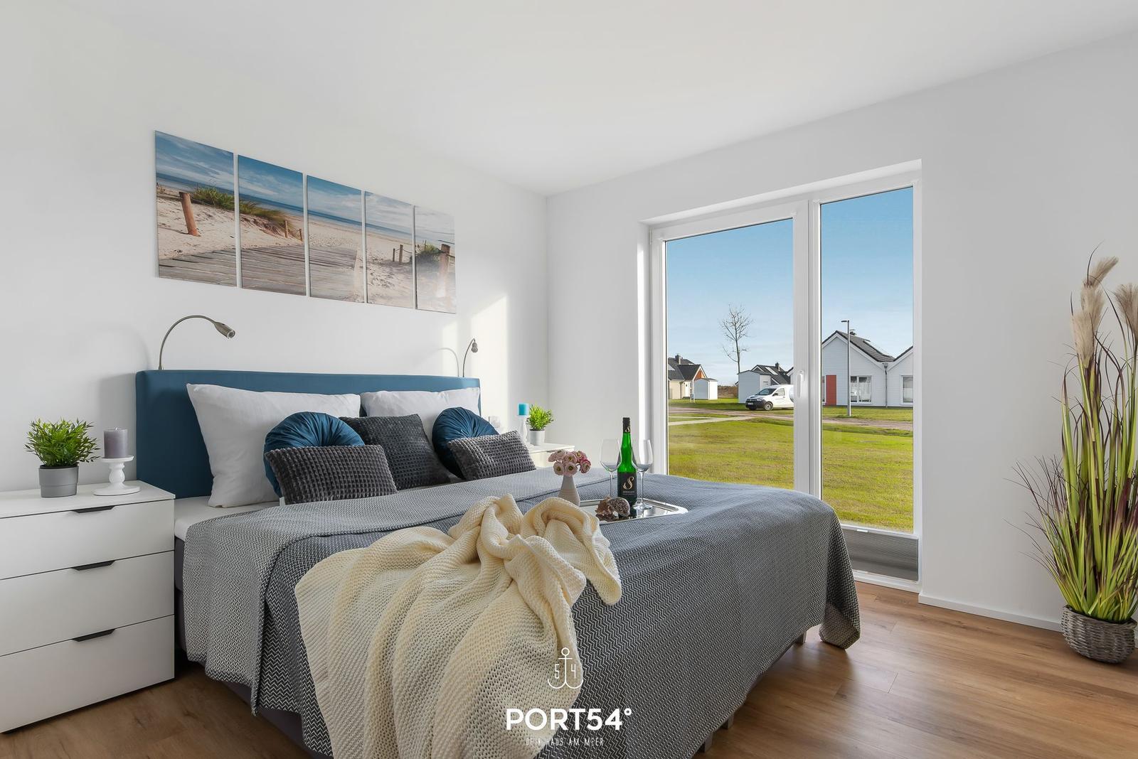 Schlafzimmer mit Bett, Fenster und Wandbild