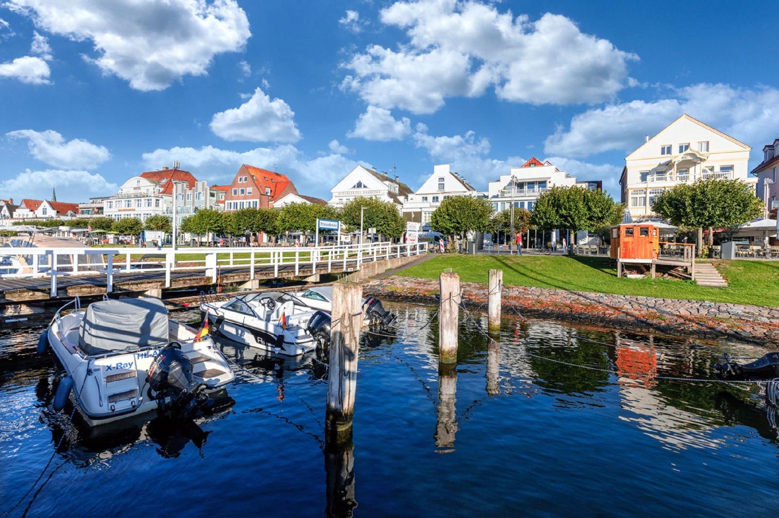 Bootshafen mit Booten und Blick auf städtische Gebäude am Wasser.