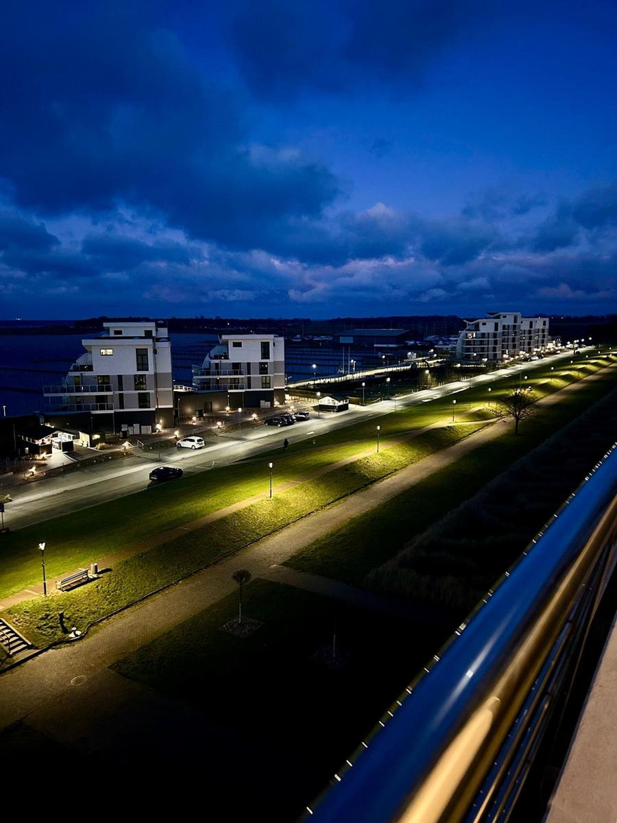 Nachtansicht von modernen Gebäuden und beleuchteten Straßen am Wasser.