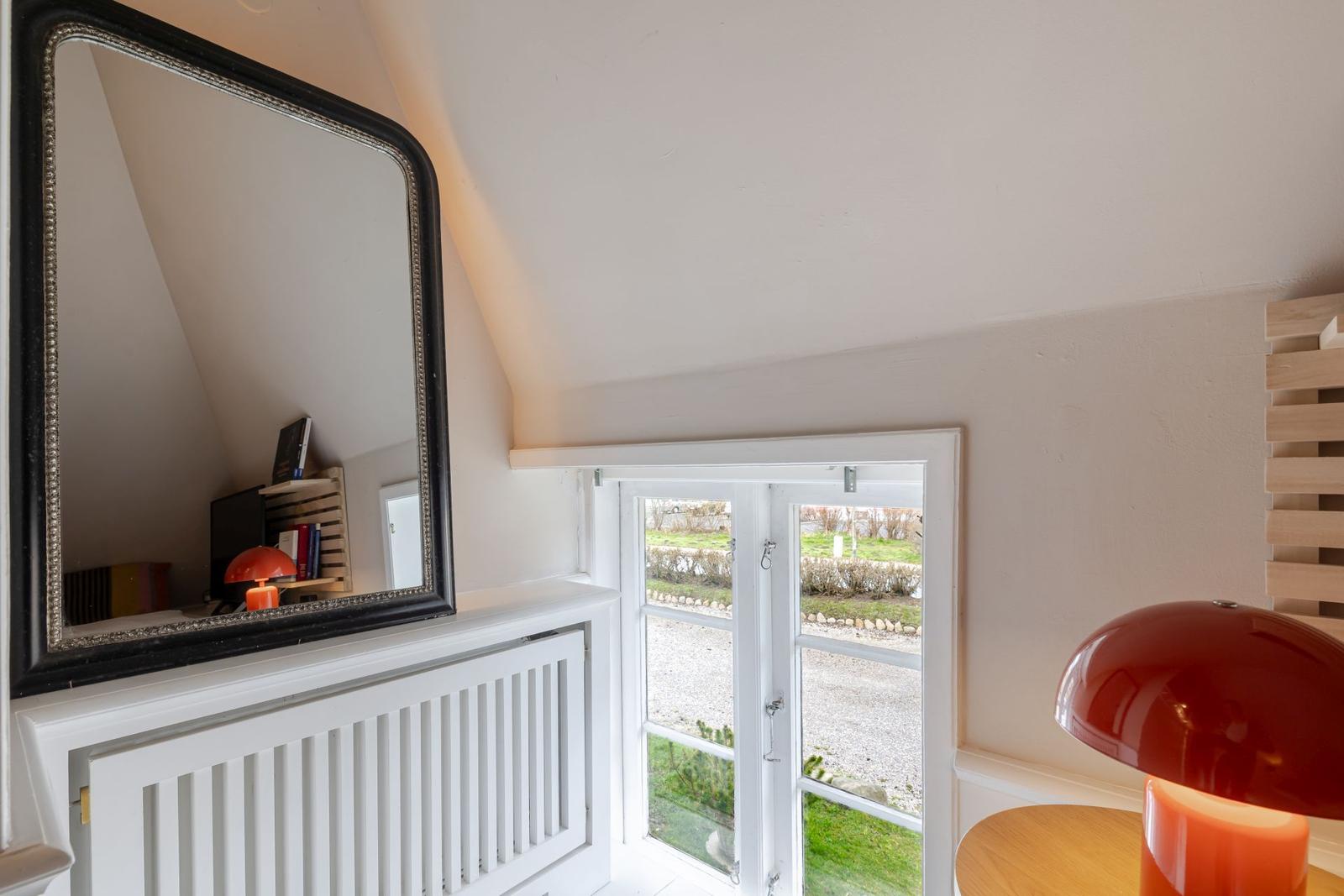 Raum mit Spiegel, Fenster und roter Lampe