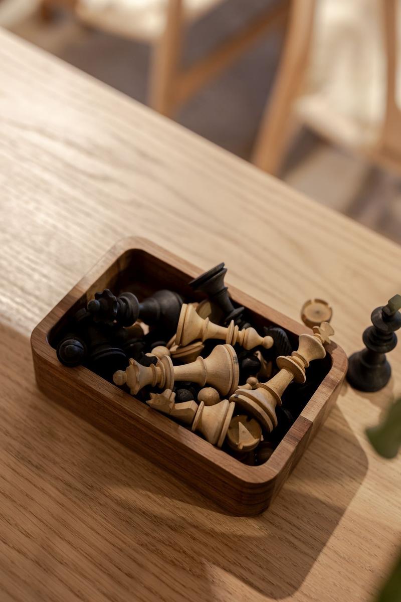 Schachfiguren in einem Holzkasten auf einem Holztisch