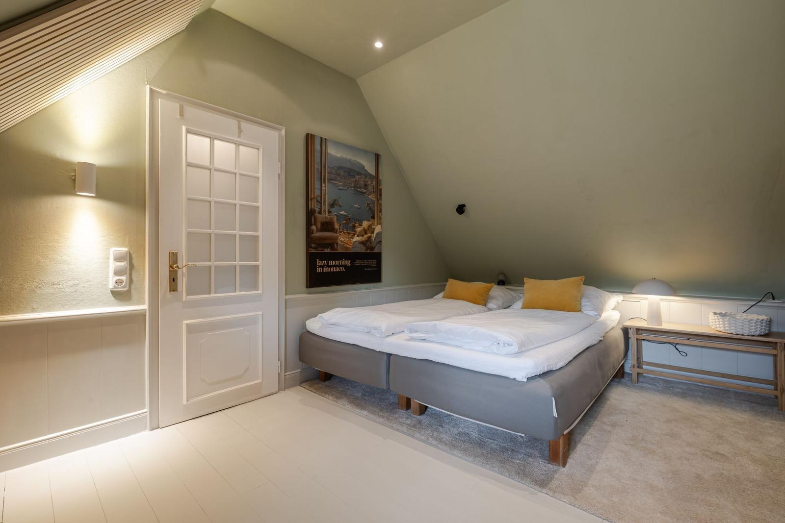 Schlafzimmer mit Doppelbett, Wandbild und Nachttisch