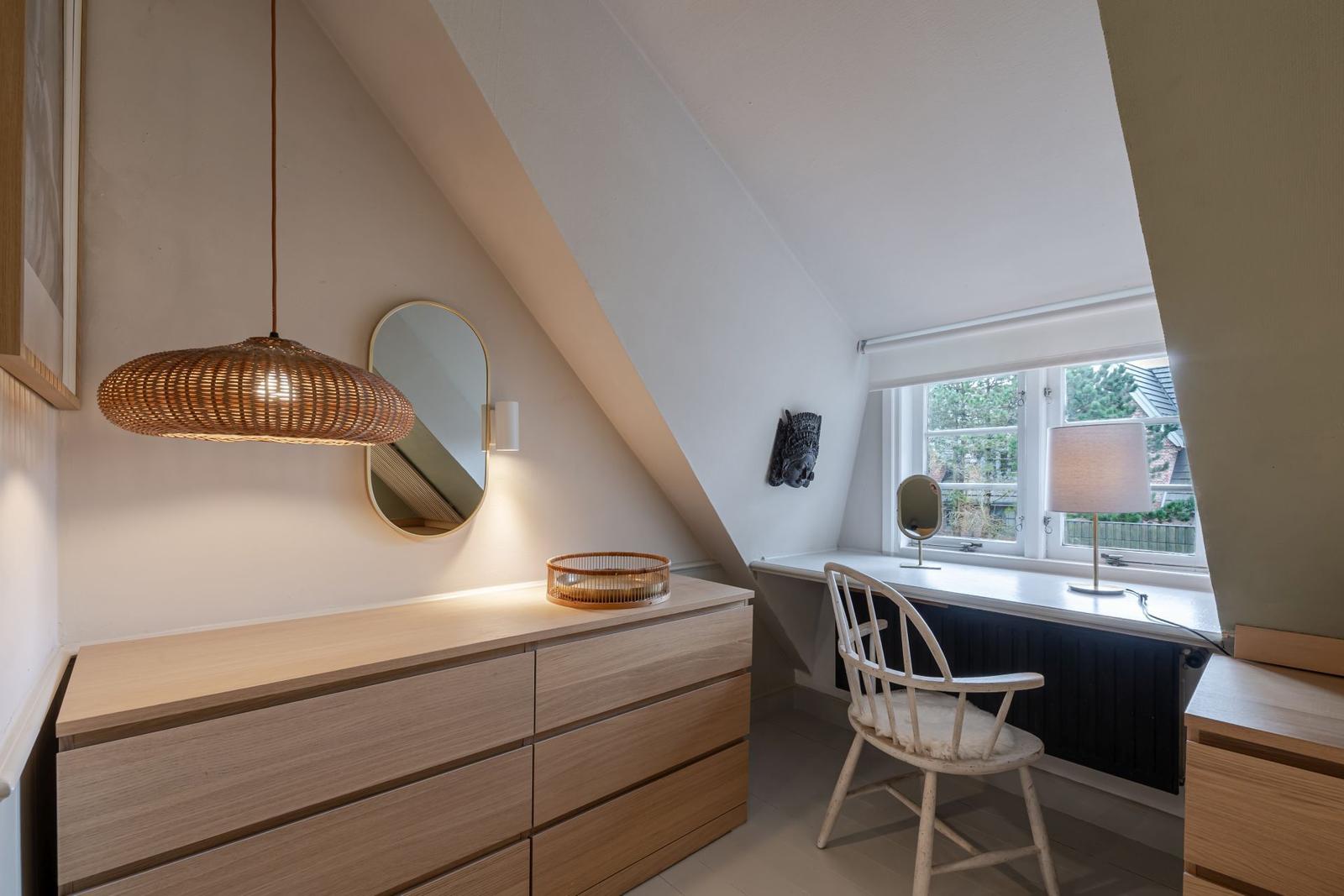 Schlafzimmer mit Schrank, Stuhl und Fenster