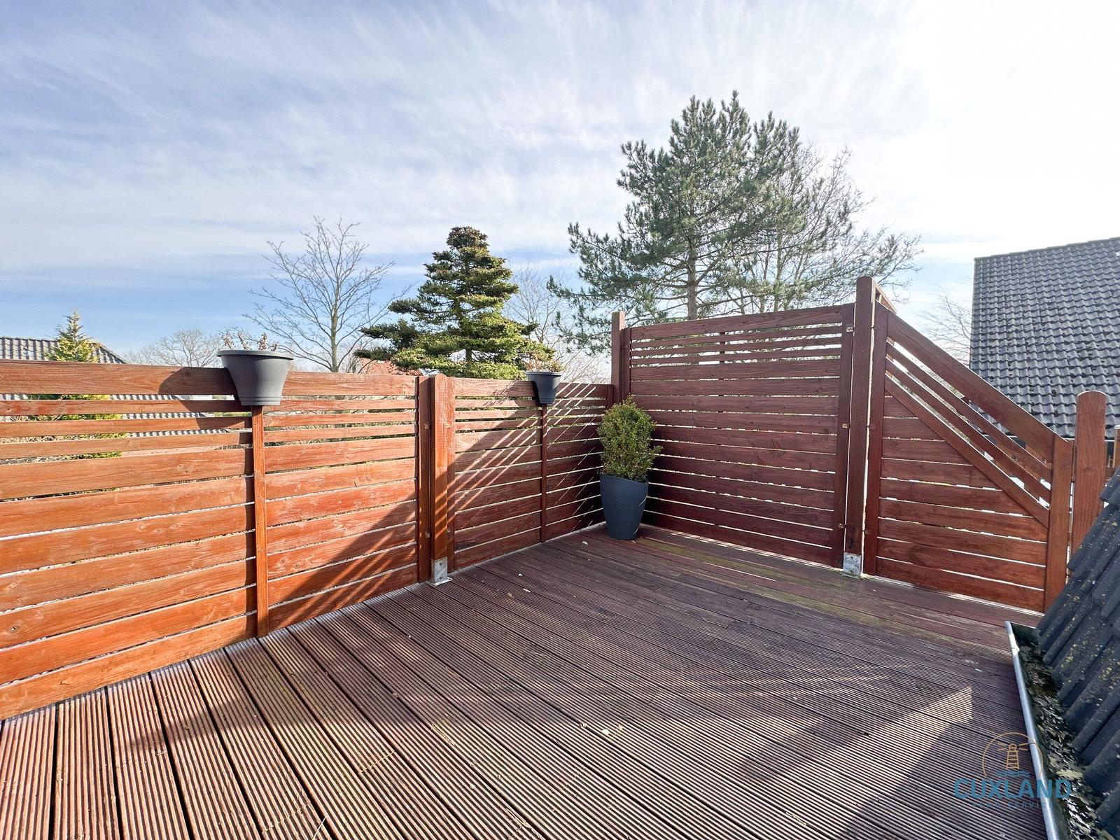 Holzterrasse mit Sichtschutzzaun und Pflanzen