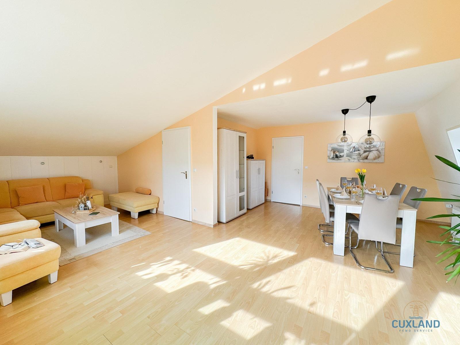 Wohn- und Essbereich mit Sofa, Esstisch und Holzboden.