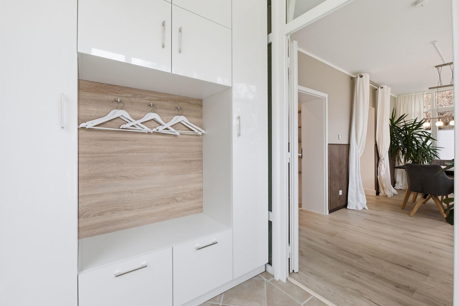 Schlafzimmer mit Kleiderschrank und Blick ins Esszimmer.