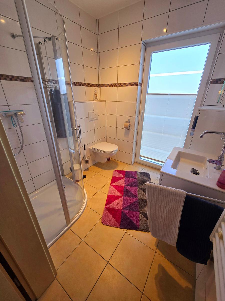Helles Badezimmer mit Dusche und funktionaler Ausstattung.