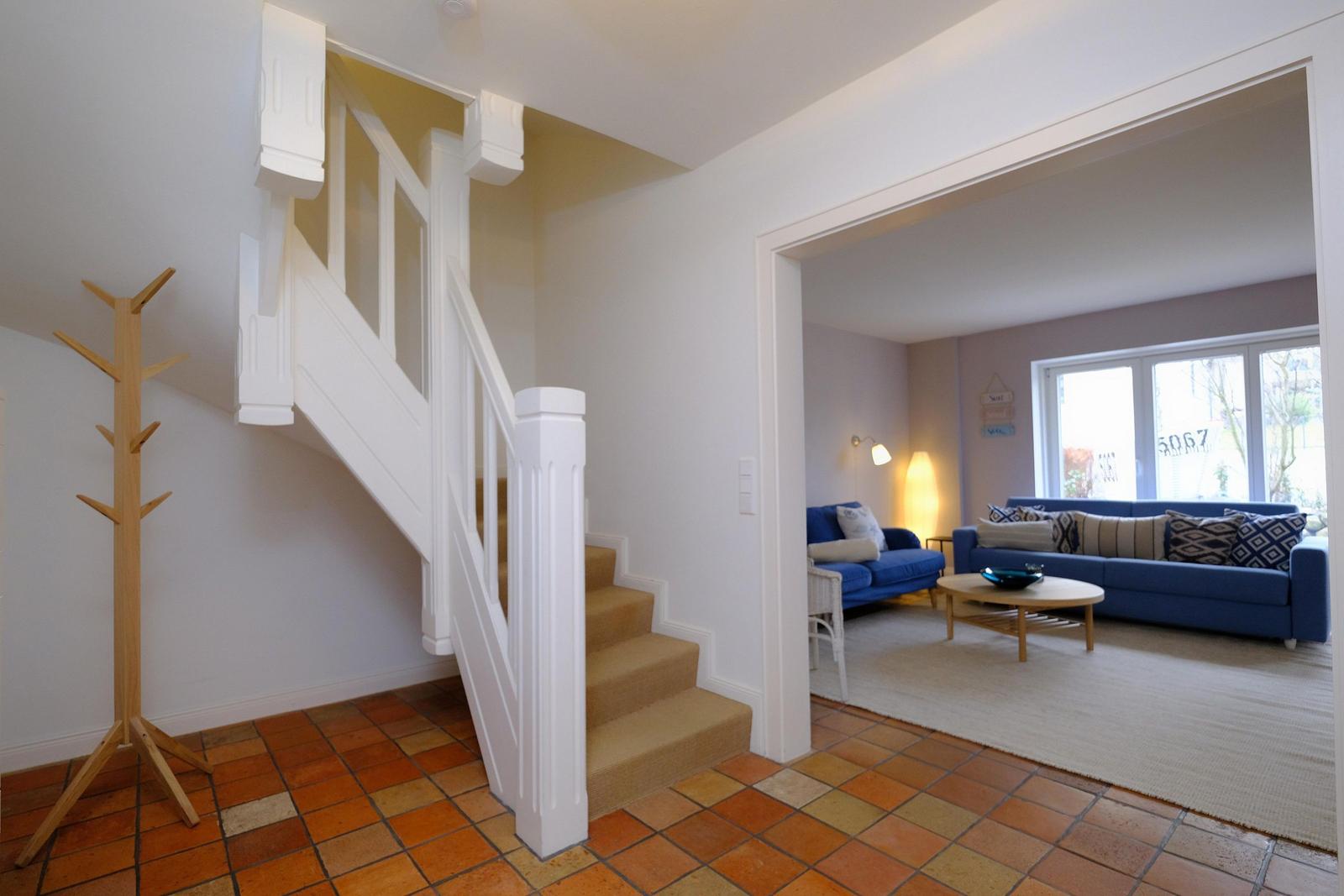 Haus mit Treppenhaus und Wohnzimmer mit blauem Sofa.