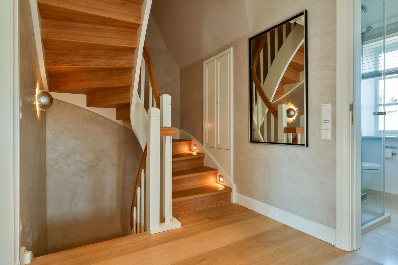 Haus mit Holztreppe, Spiegel und Badezimmer