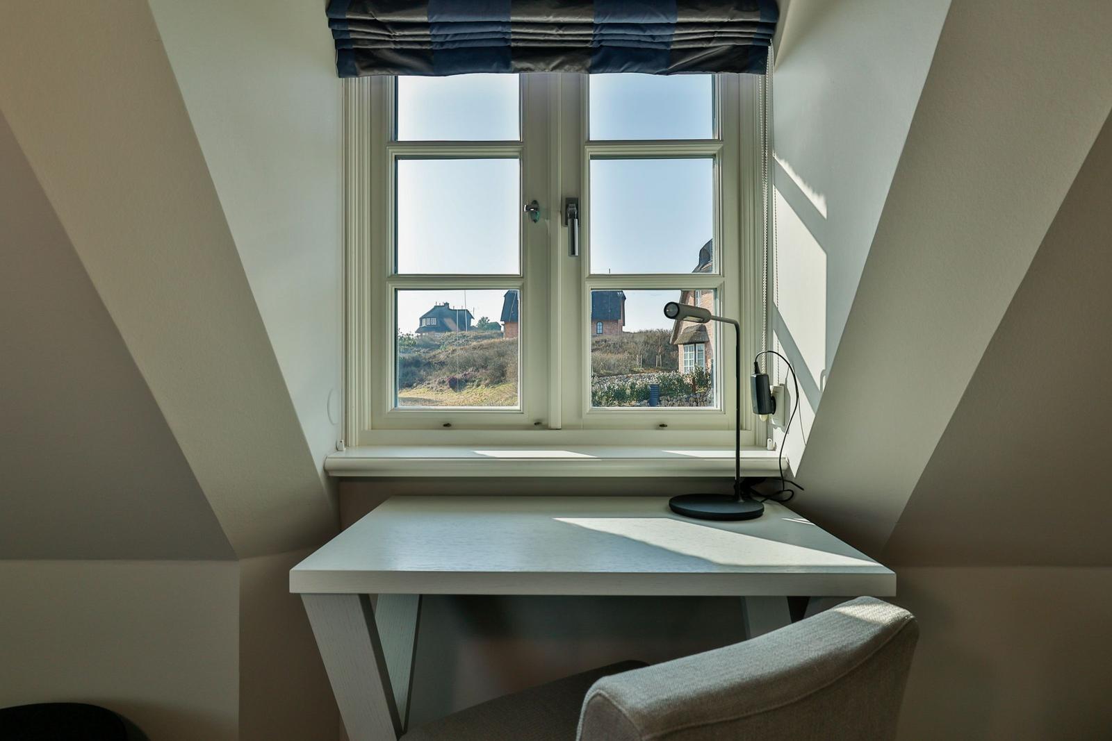 Arbeitsplatz mit Fenster und Blick auf die Landschaft