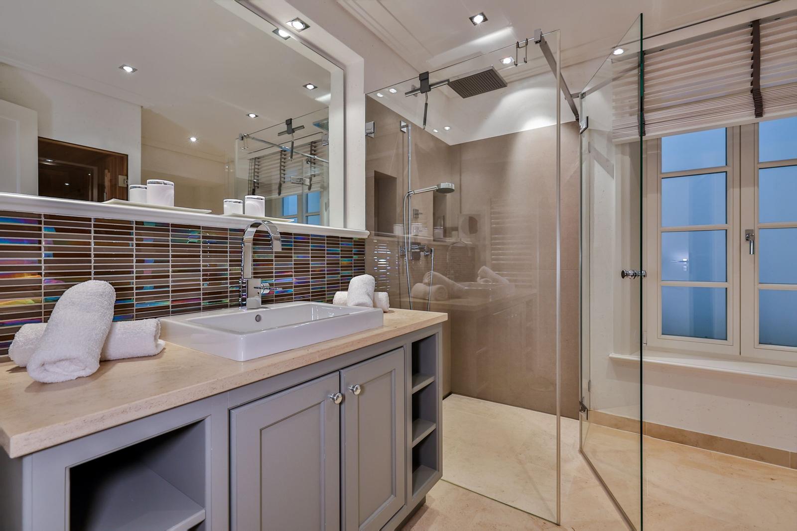 Badezimmer mit Dusche, Waschbecken und Fenster