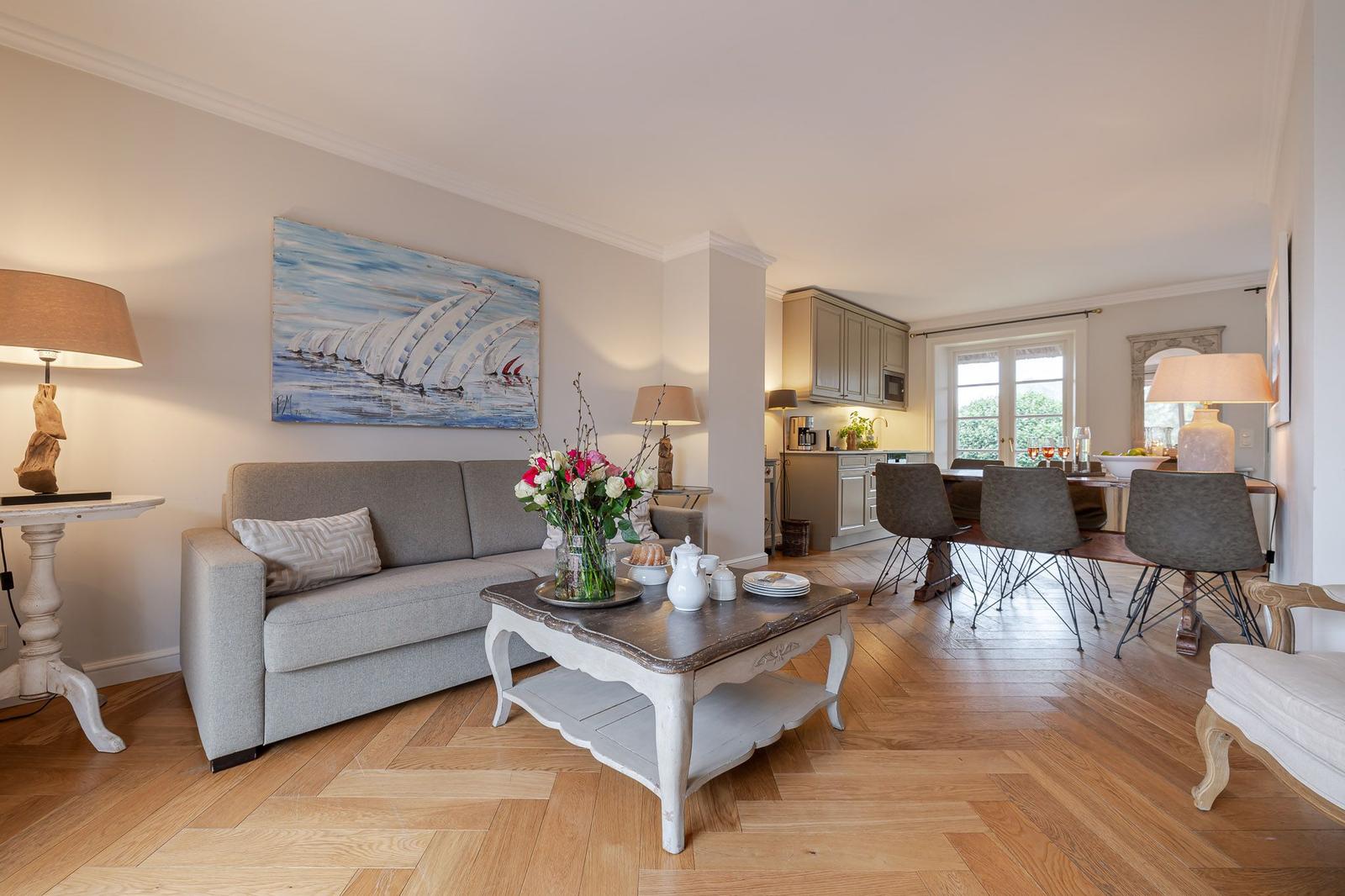 Living and dining area with sofa, table, and kitchen area.