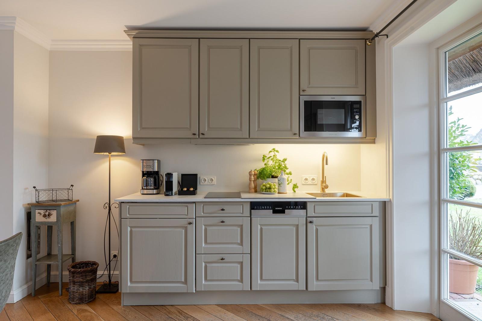 Kitchen with light cabinets, sink, and window view.