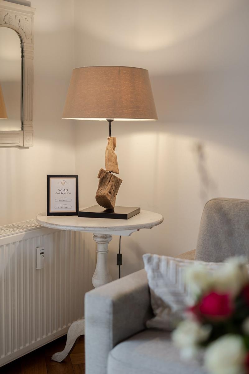 Table with lamp, WLAN sign, and armchair in room