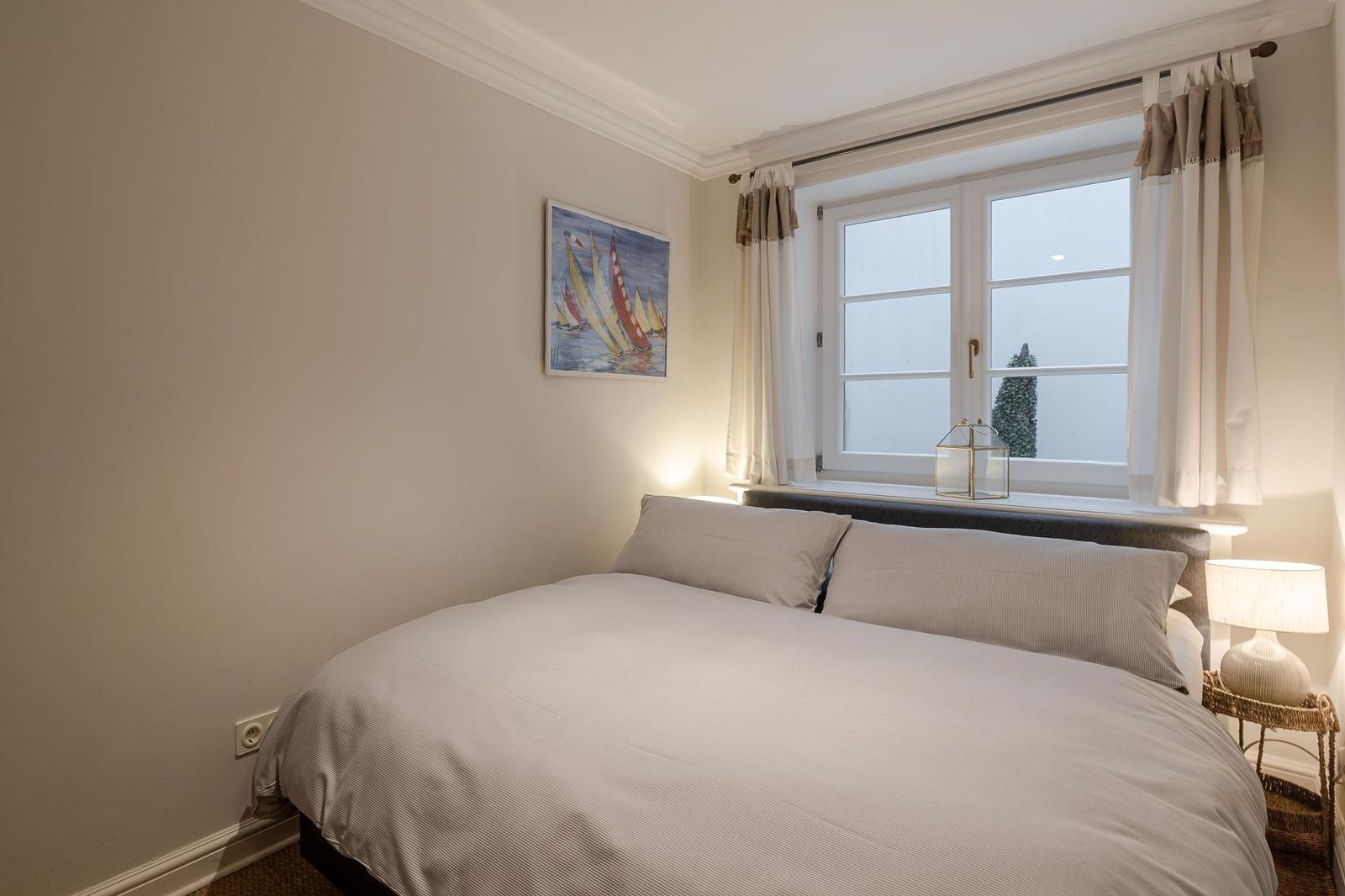 Bedroom with bed, window, and wall art.
