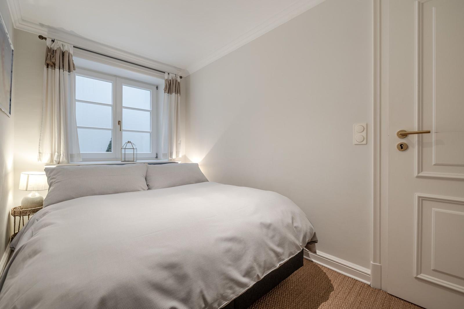 Bedroom with bed, window, and door