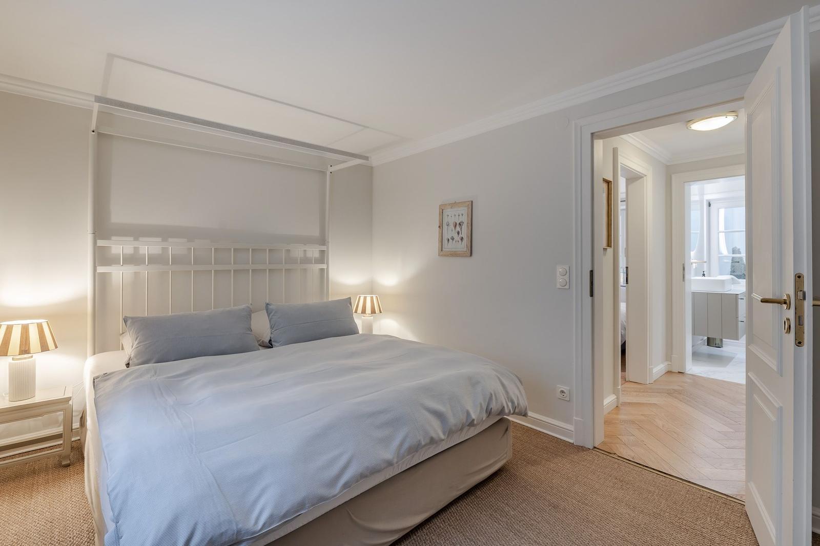 Bedroom with bed, nightstands, and view into the bathroom.