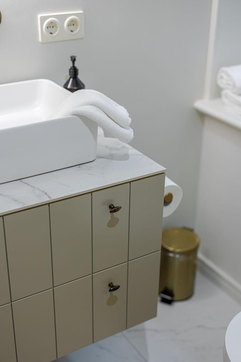 Sink with towel on marble top and beige cabinet